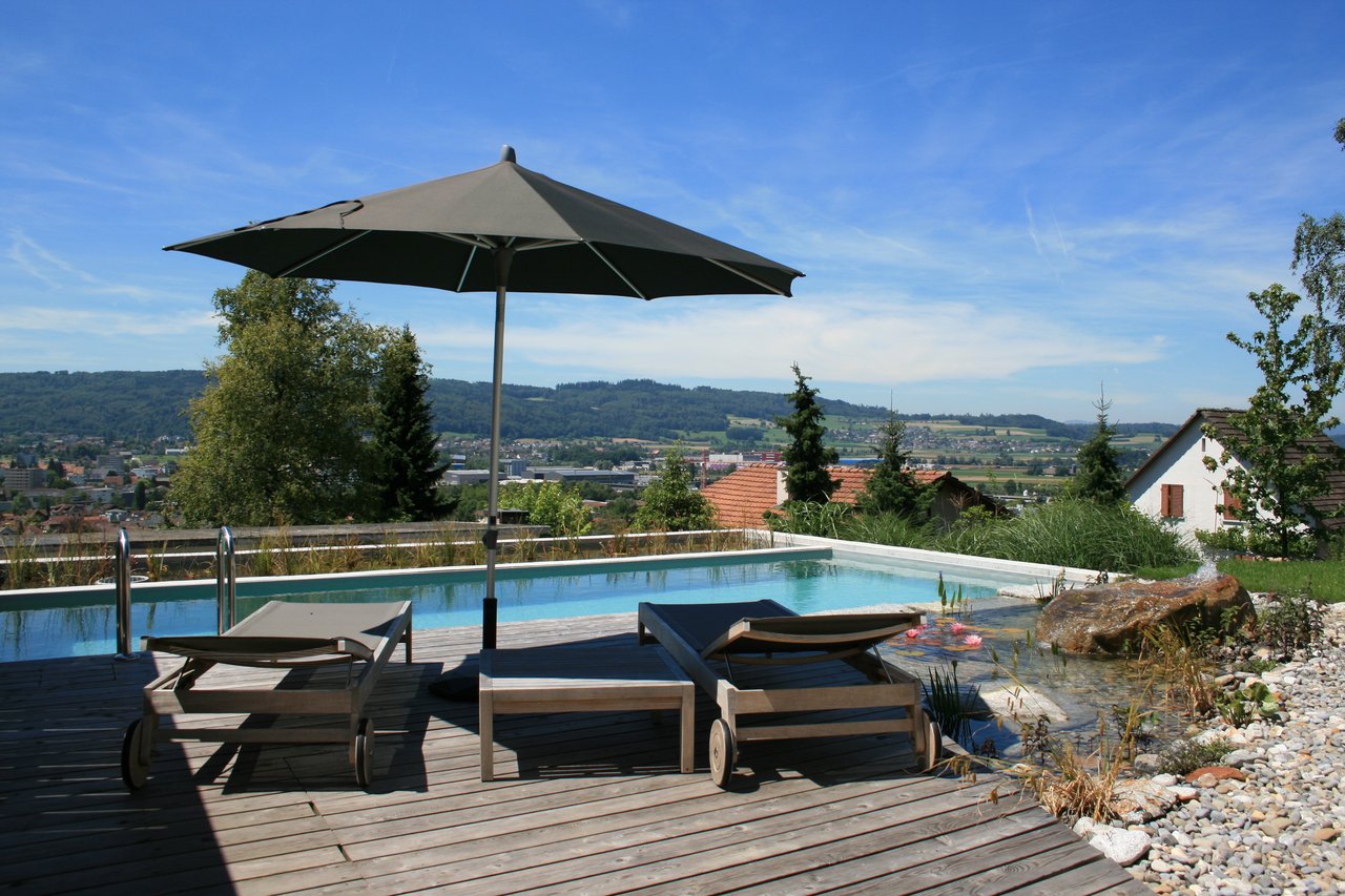 Sitzplatz mit Sonnenschirm am Pool