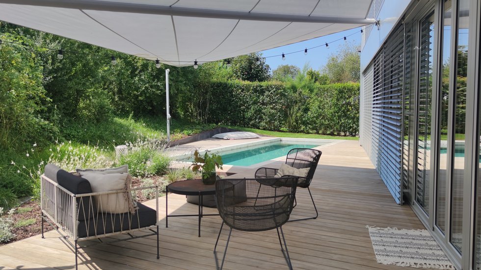 Gartenlounge auf einer Holzterrasse am Pool